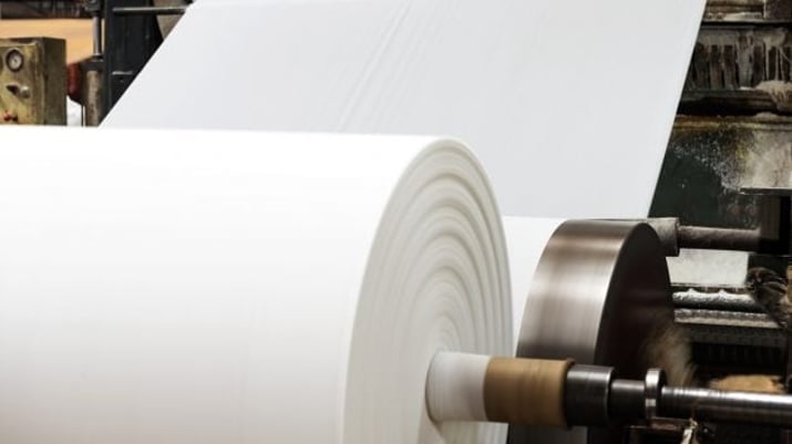 Rolo de papel numa indústria. Representa as grandes empresas do setor de papel e celulose, como Klabin (KLBN11) e Suzano (SUZB3)