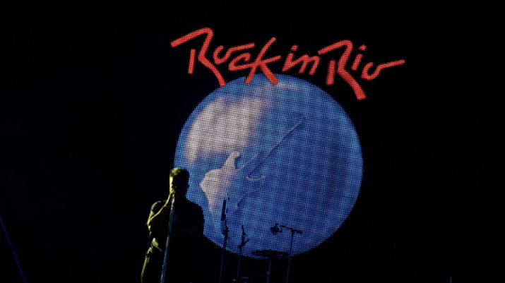 Silhueta de um músico com o logo do festival Rock in Rio atrás