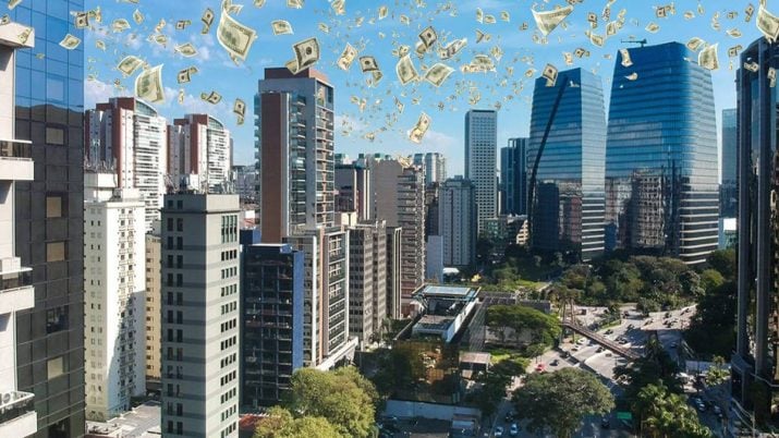 Dinheiro caindo do céu sobre prédios representando os dividendos de fundos imobiliários (IFIX) mercado