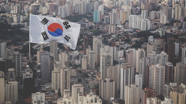Montagem com bandeira da Coreia do Sul em em meio a prédios de São Paulo