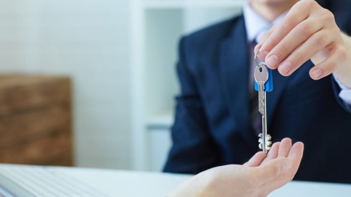 homem entrega chave da casa própria