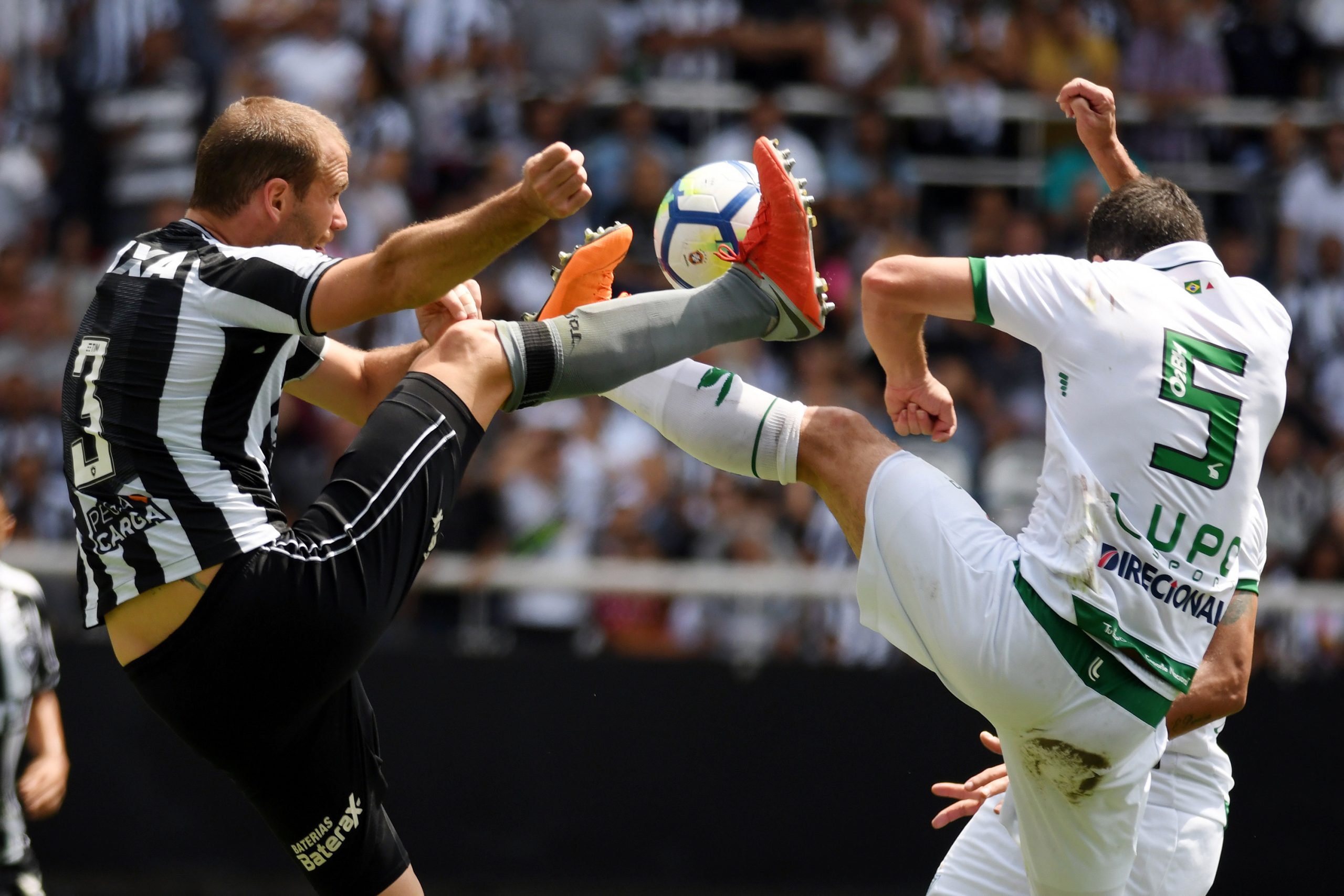 Jogadores do Botafogo e América MG disputam bola dividida