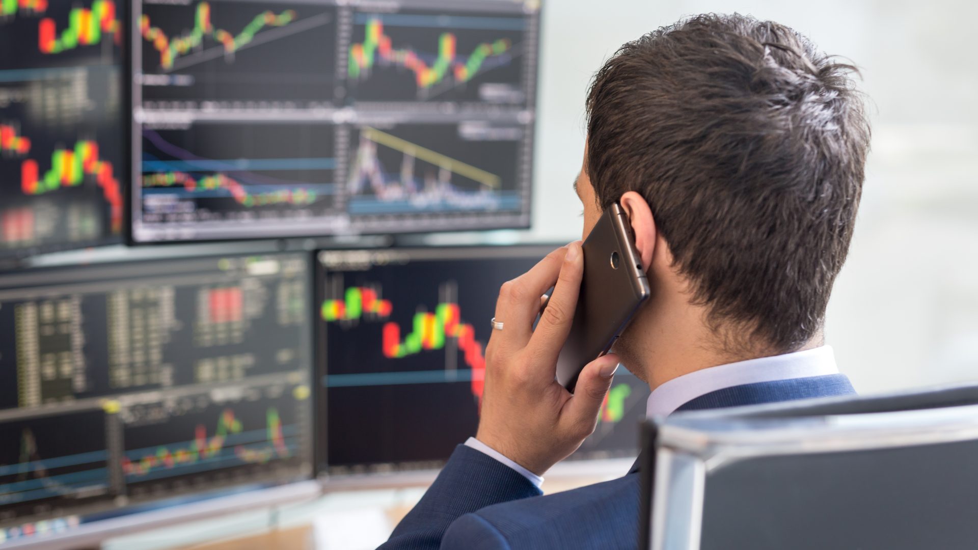 Trader em frente a terminal com várias telas