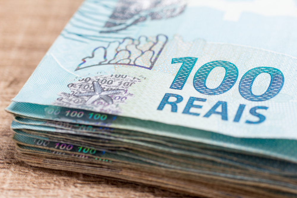 nota de dinheiro de 100 reais na mesa