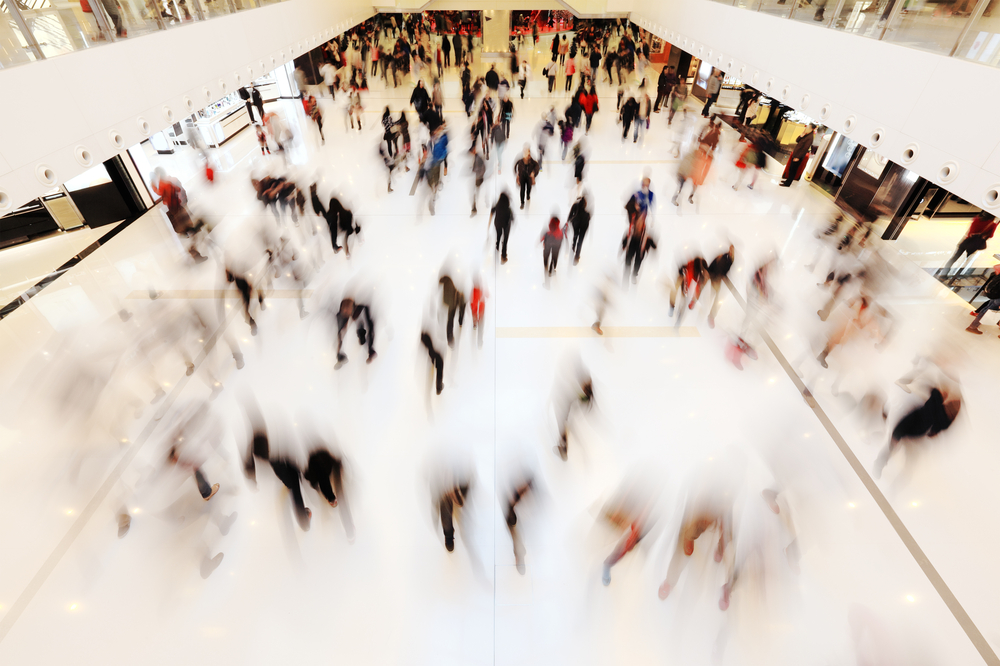 Varejo: imagem desfocada de pessoas caminhando em um shopping center