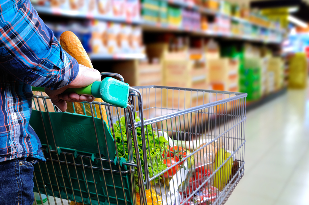 Supermercado, mulher com carrinho fazendo compras