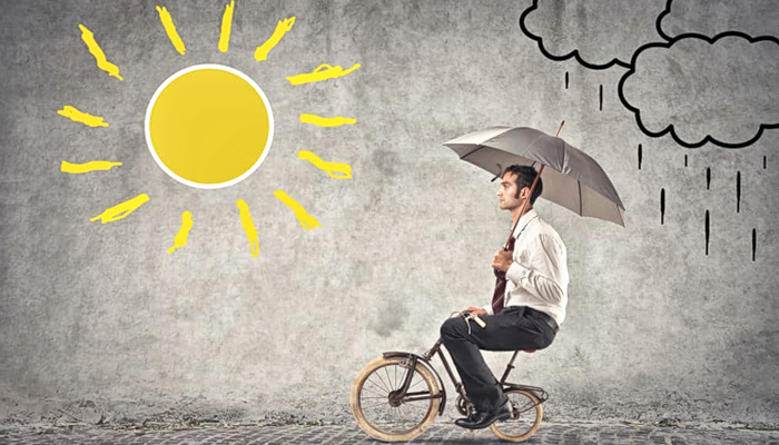Homem de bicicleta com guarda-chuva