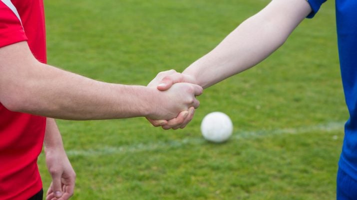 Jogadores apertam as mãos antes de começar o jogo