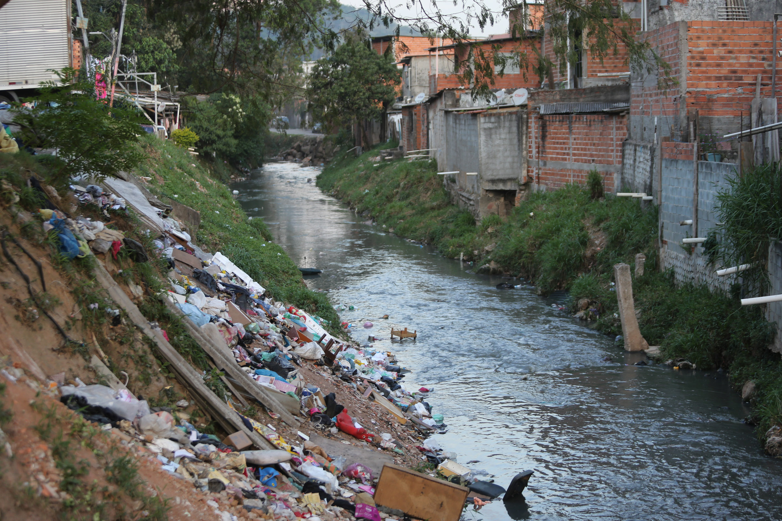 Imagem mostra lixo e córrego poluído em São Paulo