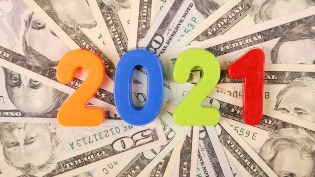 Número '2021' em cima de pilha de dinheiro
