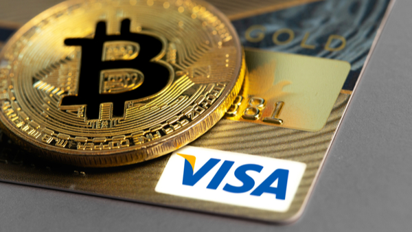 Moeda de bitcoin sobre um cartão da Visa