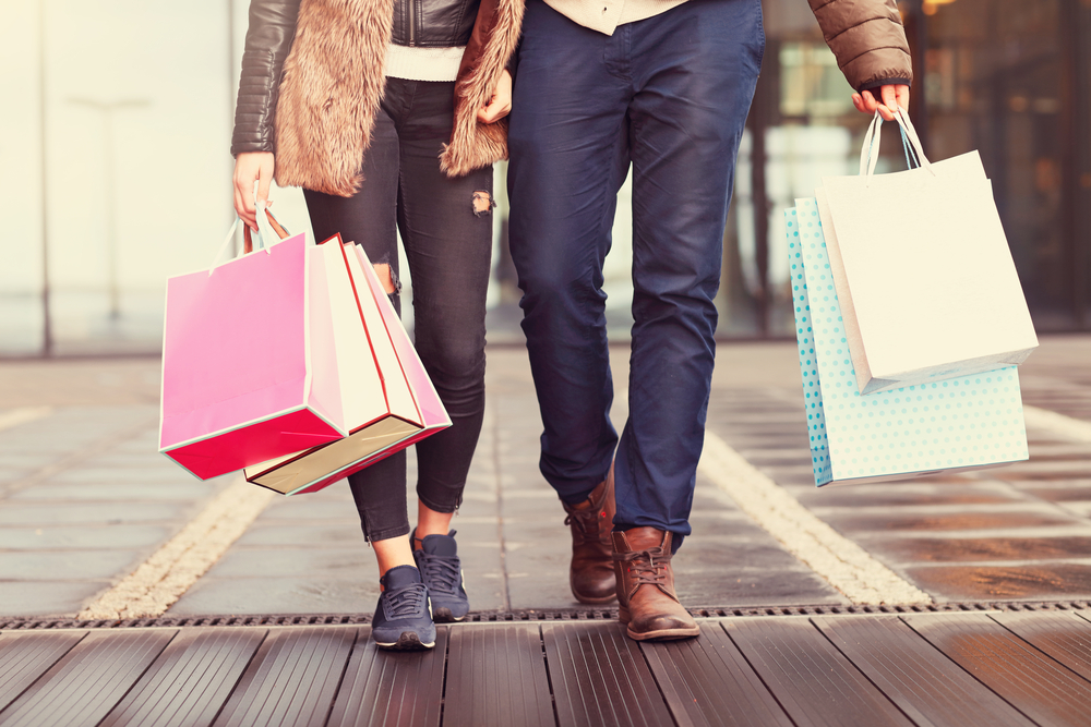 casal carrega sacolas de compras em shopping