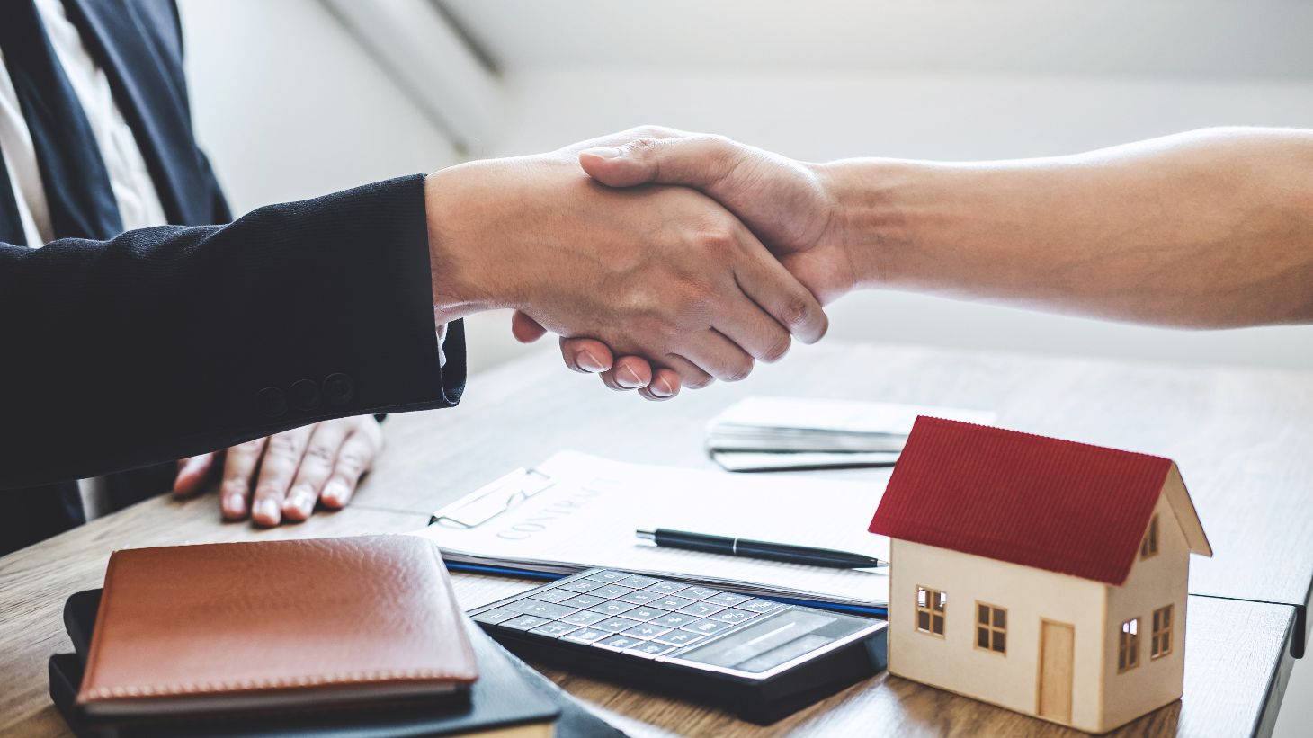 Aperto de mãos em assinatura de contrato de financiamento imobiliário