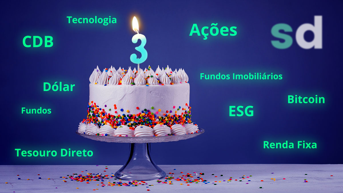 Bolo com vela de número 3 acesa, no fundo o logo do SD, as palavras renda fixa, ações, fundos imobiliários, bitcoin, CDB, fundos, debêntures, dólar, Tesouro Direto, tecnologia, ESG estão em volta do bolo