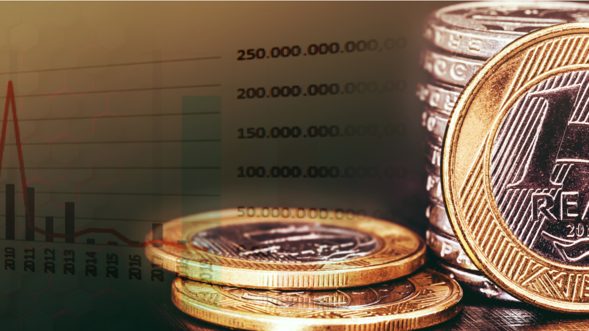 moedas de real na frente de um gráfico