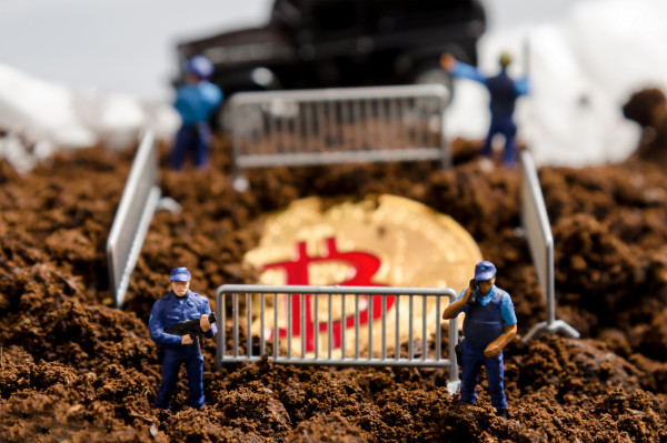 Policiais em miniatura cercam um bitcoin parcialmente enterrado | Coinbase Criptomoedas