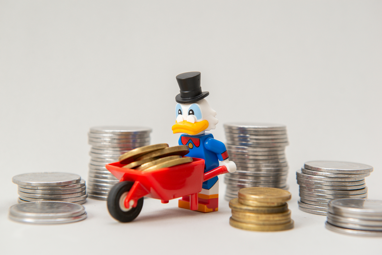 Miniatura do tio patinhas com um carrinho de mão e cercado de pilhas de moeda | Dividendos fundos imobiliários XPCM11