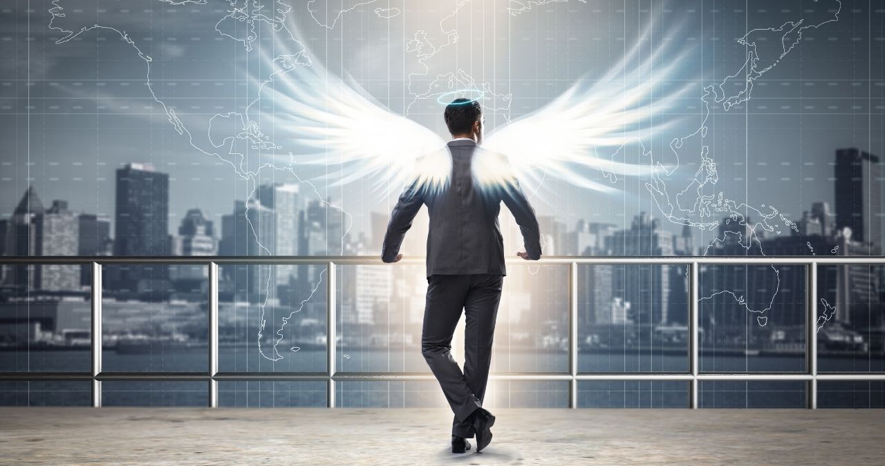 Homem com asas em varanda de um prédio, representando um investidor-anjo de startups.
