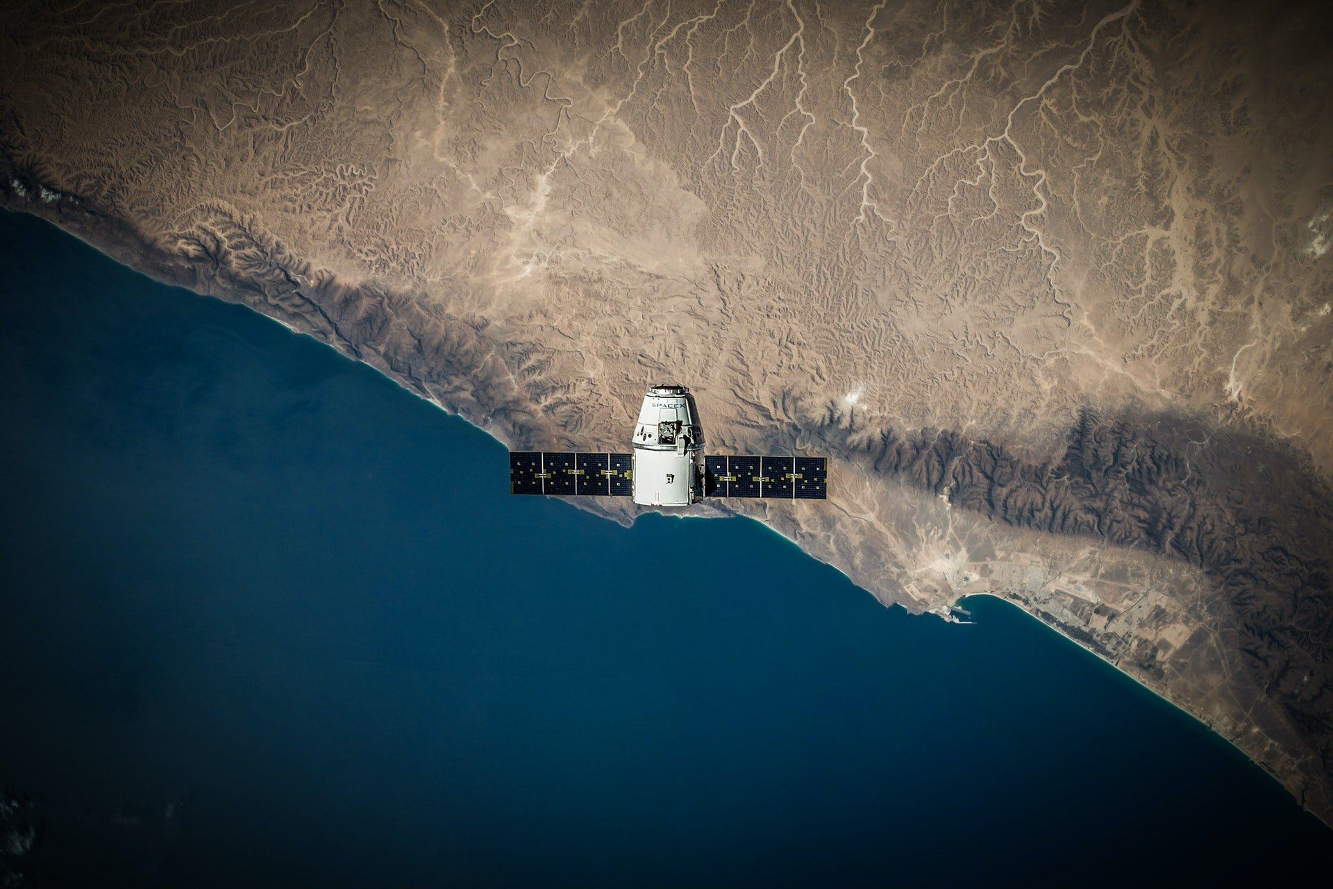 Imgem de um dos satélites fabricados pela Starlink, projeto da SpaceX, sobrevoando a Terra | Elon Musk