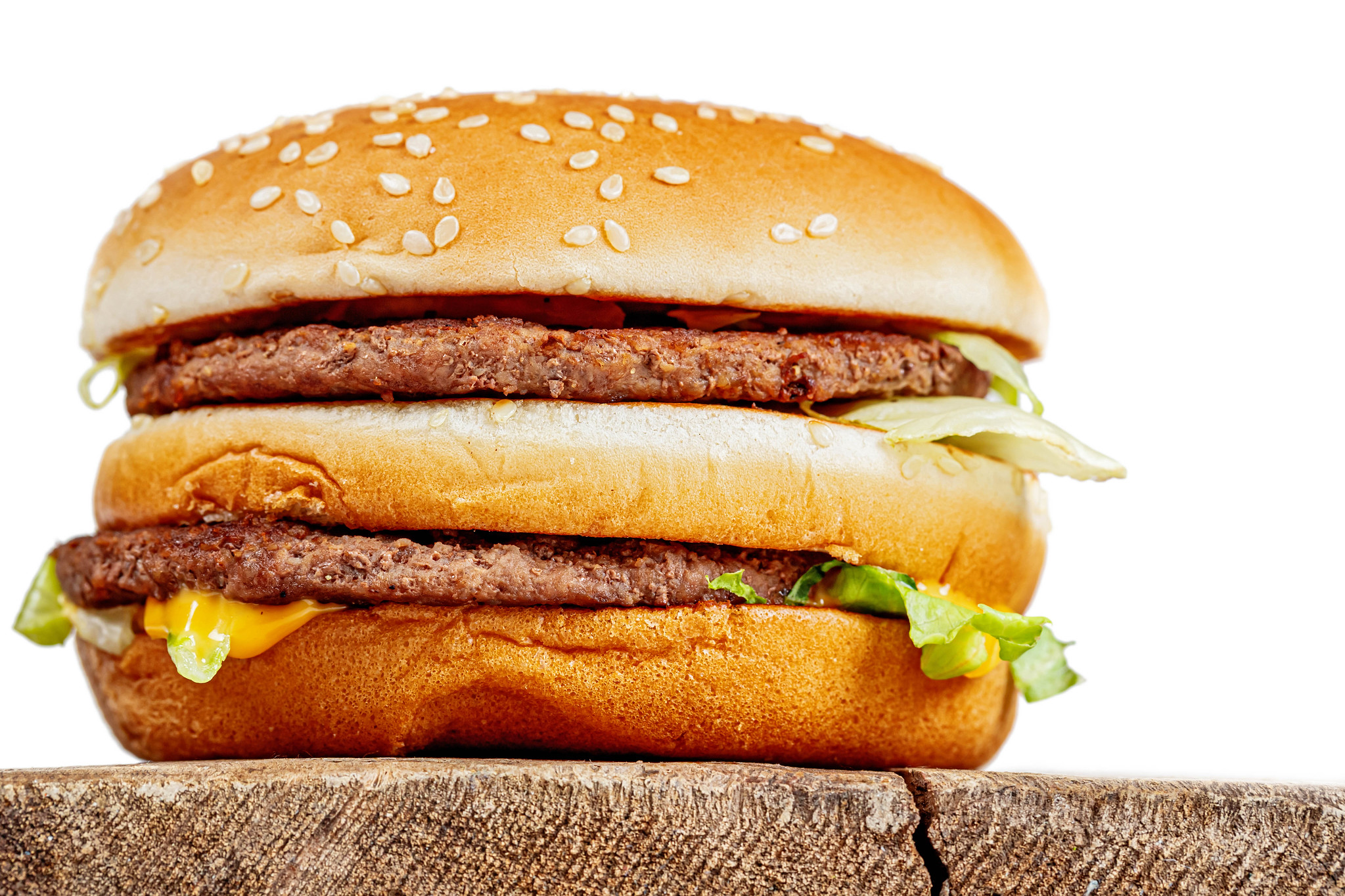 Foto de um Big Mac sobre uma bancada de madeira