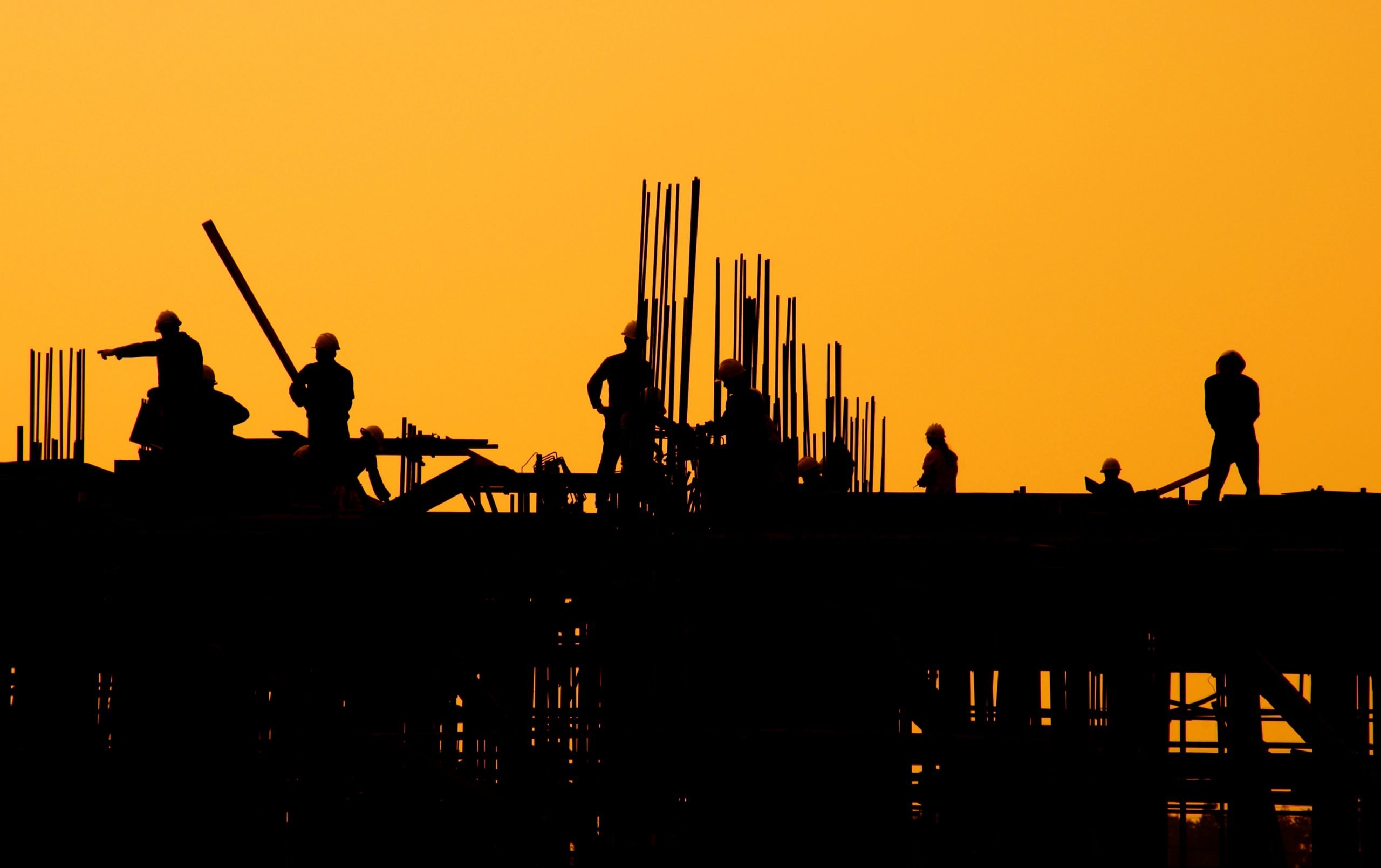 Silhueta de trabalhadores da construção civil no pôr do sol | Construtoras, Cury, PDG PDGR3, ações JP Morgan Casa Verde e Amarela Distratos TENDA Santander Ações ação