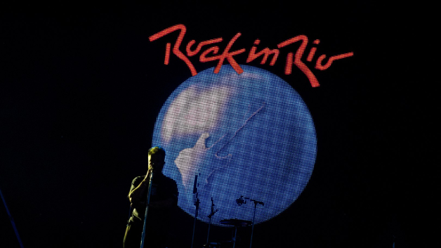 Silhueta de um músico com o logo do festival Rock in Rio atrás