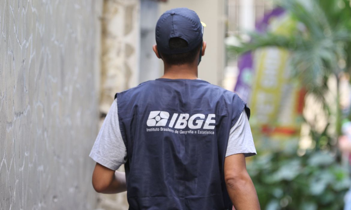 homem de costas com colete azul escrito IBGE em letras brancas