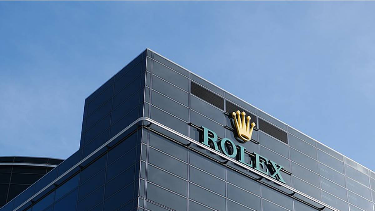 Prédio de vidro com o logo da Rolex no topo