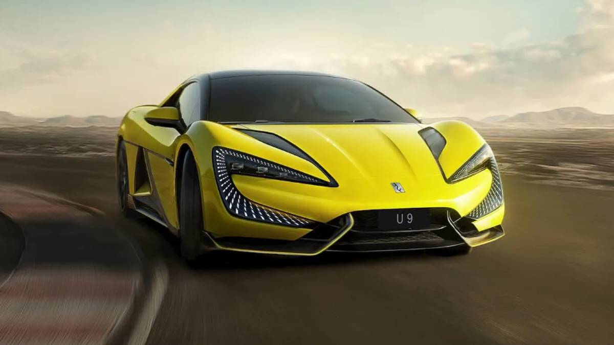 Um carro esportivo elétrico chinês amarelo, passando pela curva de uma pista de corrida