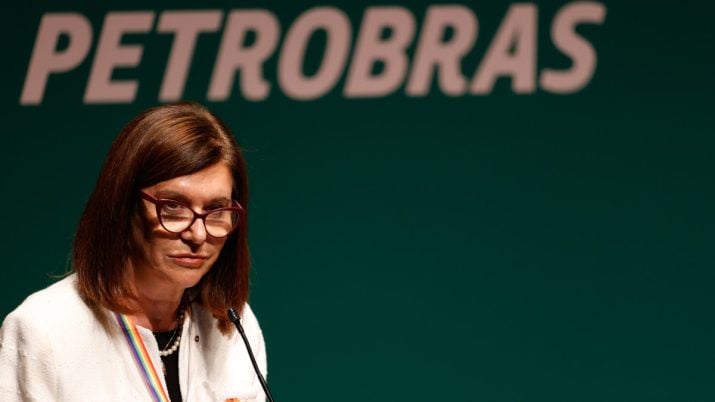 Magda Chambriard em primeiro plano com fundo verde atrás dela, com os dizeres Petrobras em branco