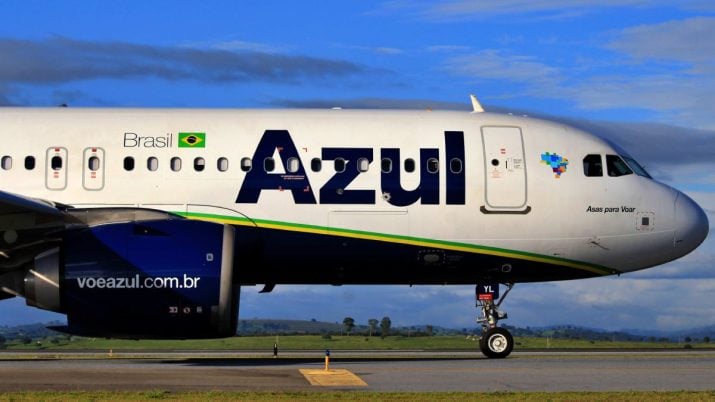 Aeronave da companhia Azul estacionado, com céu azul ao fundo.