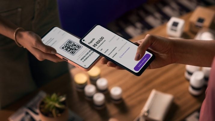 Pessoa aproxima celular com aplicativo Nubank a outro celular com QR Code na tela