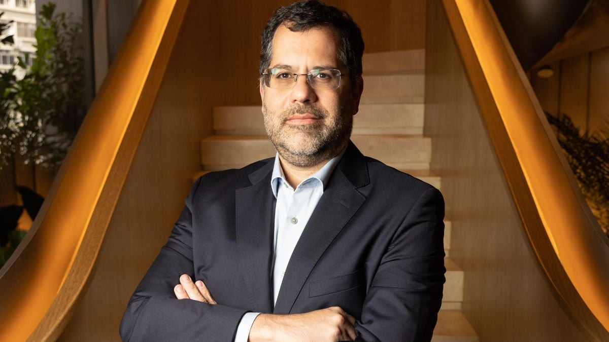 Marcelo Nantes de Souza, head de renda variável do Asa, diante de uma escada marrom. Ele está de terno e usa óculos, moreno.